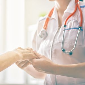 患者の手を握る看護師