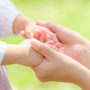 子どもの手を握る女性の手