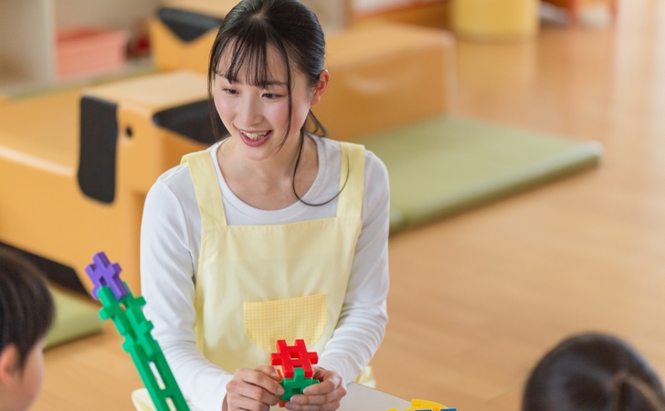 子どもと遊ぶ保育士 