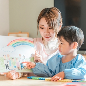 子どもに絵を見せる保育士さん 