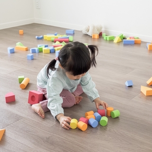 室内で玩具を使い一人遊びを楽しむ子ども
