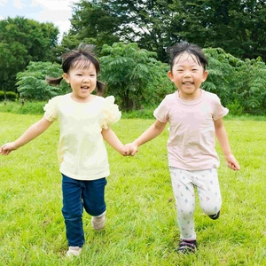 手をつないで笑顔の子ども 