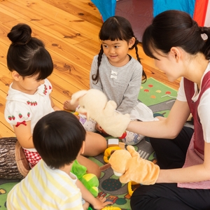 人形で遊ぶ子どもたちと保育者 