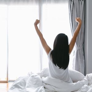 ベッドで起床する女性