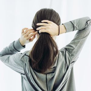 髪を結ぶ女性