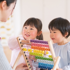 玩具で遊ぶ子どもと保育者 