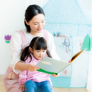 先生に絵本を読んでもらう子ども
