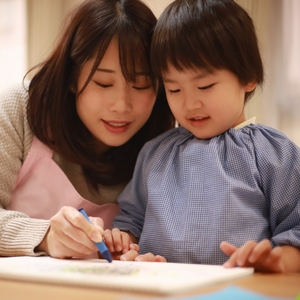 先生と一緒に絵を書く子ども
