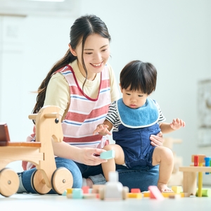 保育者とおもちゃで遊ぶ子ども
